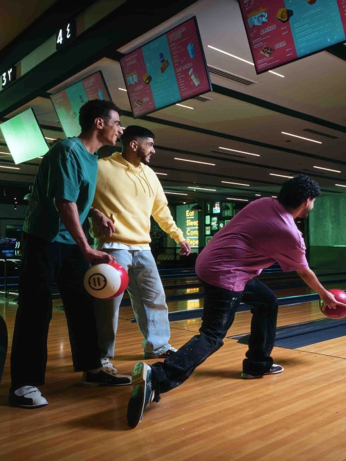 3 boys having fun while bowling